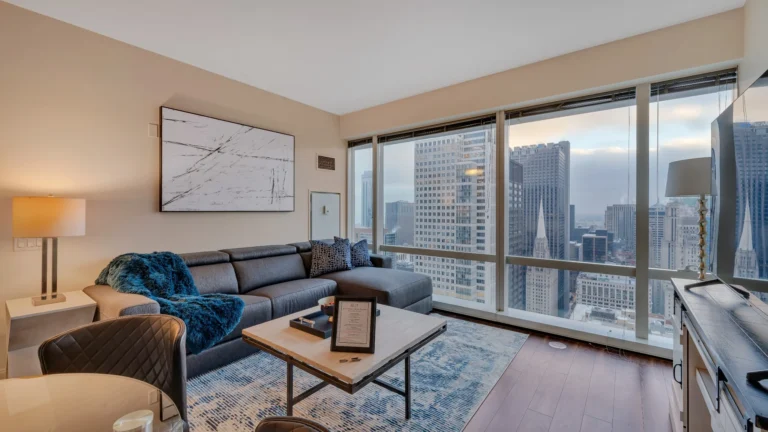 Modern furnished corporate apartment in Chicago with open living area, bedroom, and skyline views